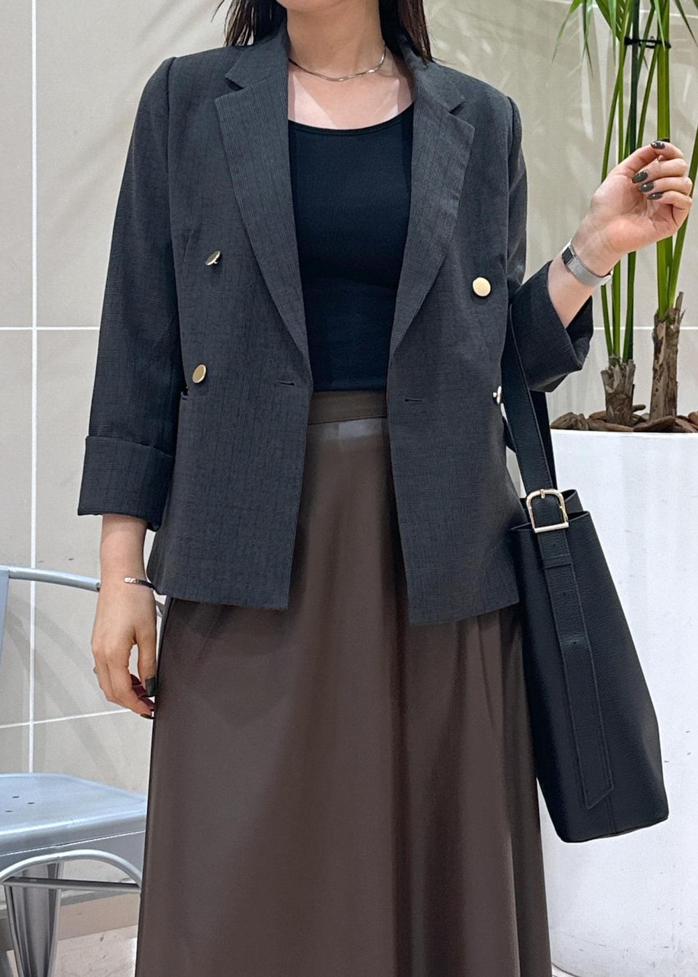 ブラック系のショルダーバッグ、ブラック系のテーラードジャケット、ブラウン系のスカートを着用したレディースの秋コーディネートの7枚目の写真