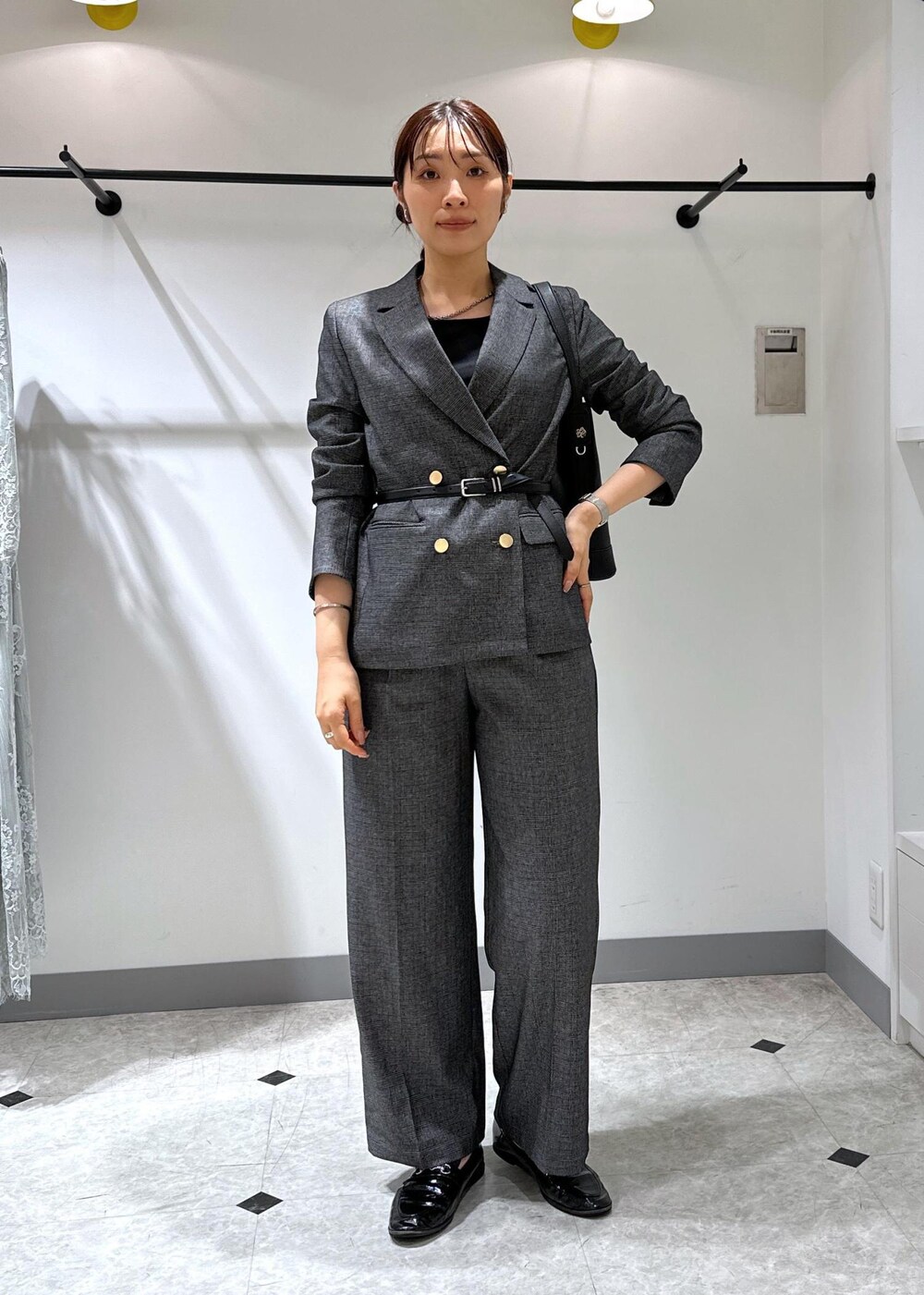 ブラック系のタンクトップ、グレー系のテーラードジャケット、グレー系のスラックスを着用したレディースの夏コーディネートの2枚目の写真