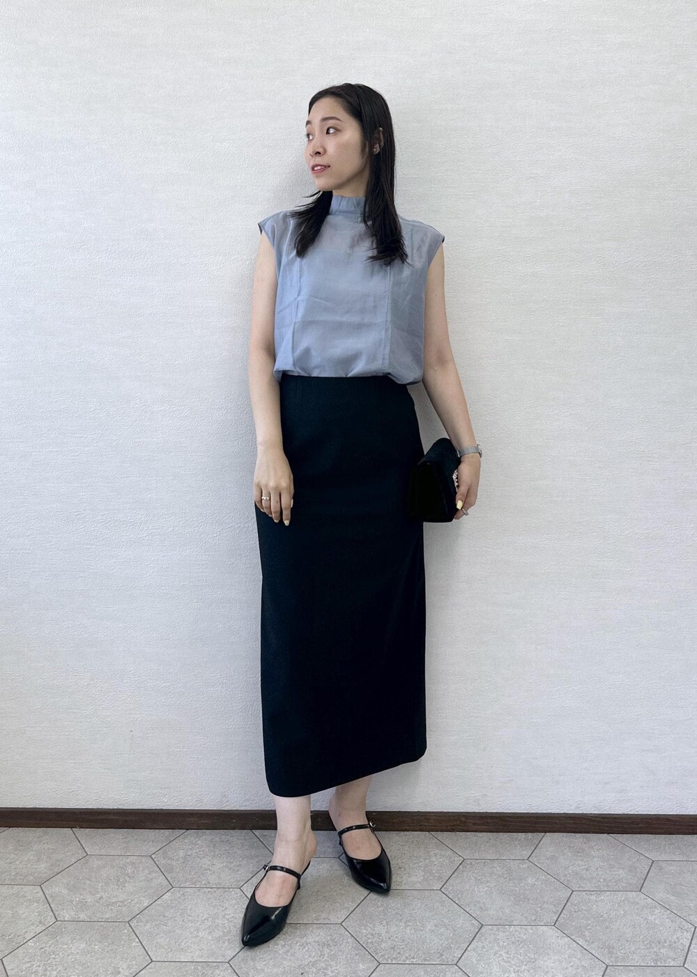 ブラック系のショルダーバッグ、ブラック系のスカート、ブラック系のパンプスを着用したレディースの夏コーディネートの4枚目の写真