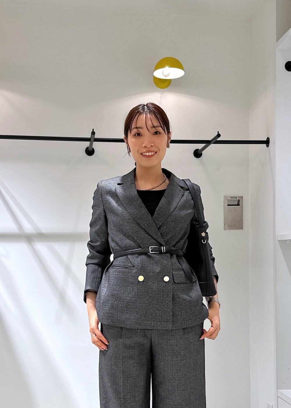 ブラック系のタンクトップ、グレー系のテーラードジャケット、グレー系のスラックスを着用したレディースの夏コーディネートの9枚目の写真