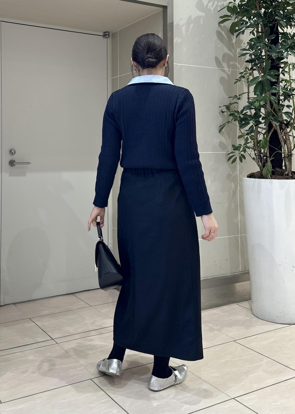 ブルー系のスカート、ブルー系のニット/セーター、ブラック系のショルダーバッグを着用したレディースの冬コーディネートの4枚目の写真