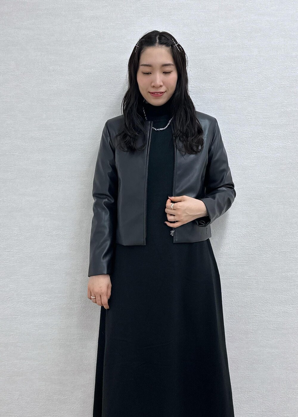 ブラック系のワンピース、ブラック系のノーカラージャケット、シルバー系のトートバッグを着用したレディースの冬コーディネートの6枚目の写真