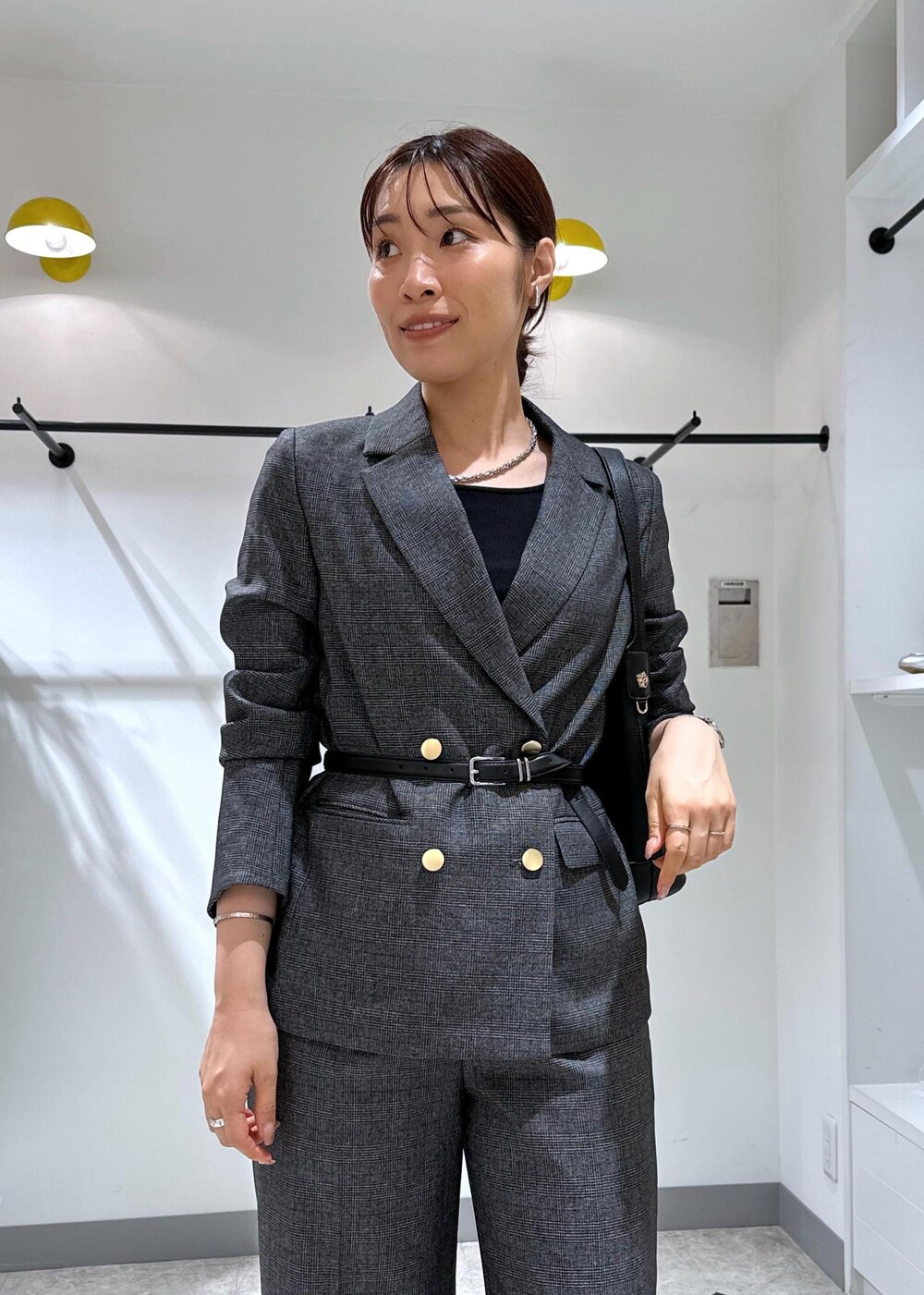 ブラック系のタンクトップ、グレー系のテーラードジャケット、グレー系のスラックスを着用したレディースの夏コーディネートの8枚目の写真