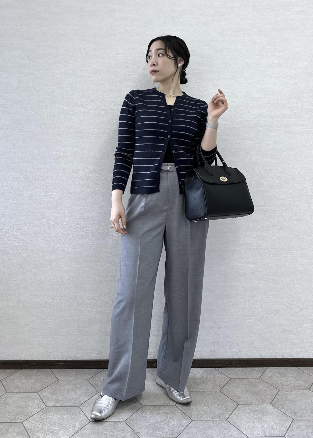 ブラック系のトートバッグ、ブラック系のタンクトップ、ブルー系のカーディガン/ボレロを着用したレディースの春コーディネートの4枚目の写真