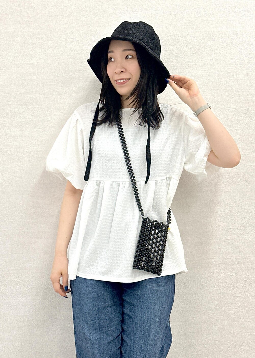 ブラック系のショルダーバッグ、ブルー系のデニムパンツ、ホワイト系のシャツ/ブラウスを着用したレディースの春コーディネートの5枚目の写真