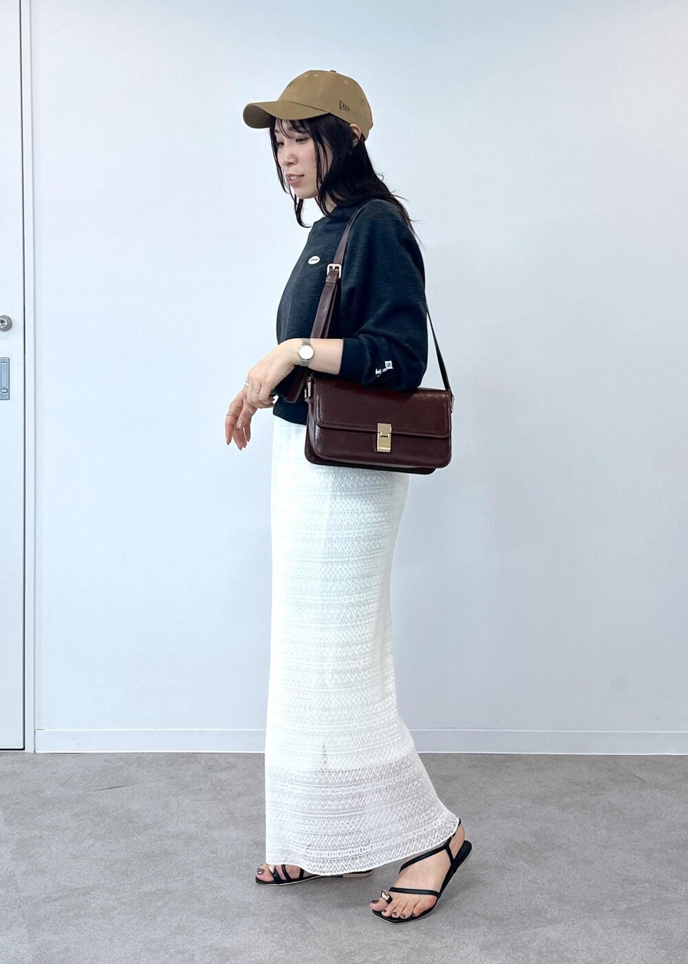 ブラック系のサンダル、ホワイト系のスカート、レッド系のショルダーバッグを着用したレディースの夏コーディネートの5枚目の写真