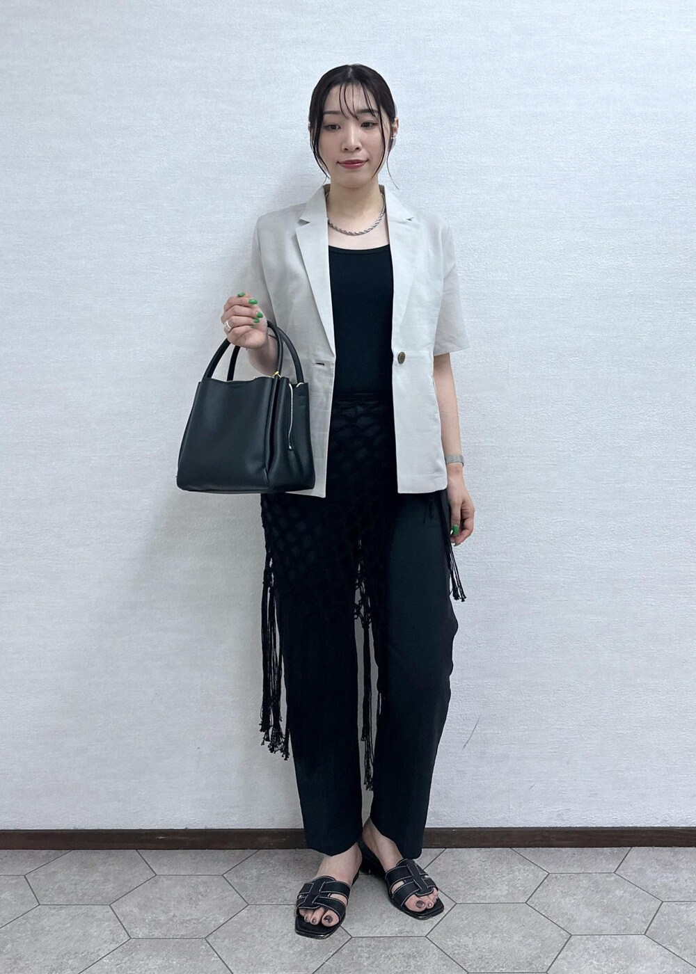ブラック系のショルダーバッグ、ベージュ系のテーラードジャケット、グレー系のその他パンツを着用したレディースの夏コーディネートの4枚目の写真