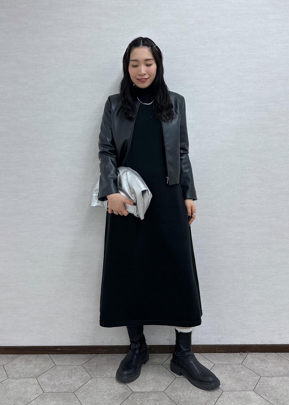 ブラック系のワンピース、ブラック系のノーカラージャケット、シルバー系のトートバッグを着用したレディースの冬コーディネートの2枚目の写真