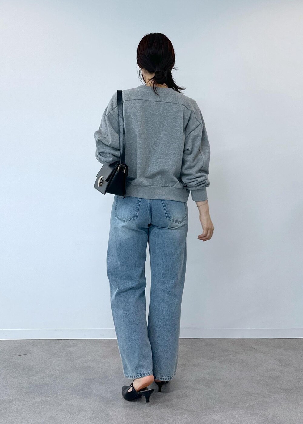 グレー系のデニムパンツ、ホワイト系のタンクトップ、ブラック系のショルダーバッグを着用したレディースの夏コーディネートの6枚目の写真