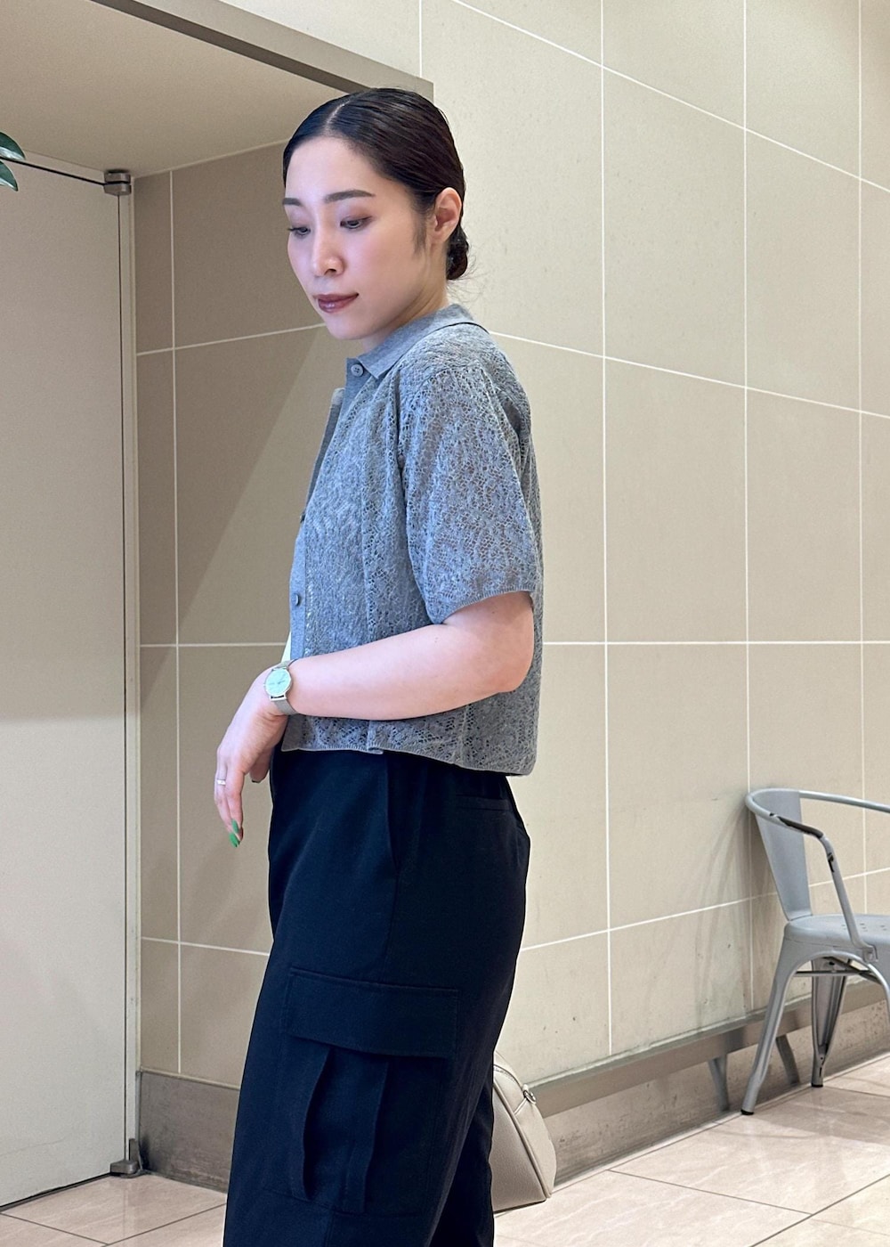 ベージュ系のボストンバッグ、ブラック系のカーゴパンツ、ホワイト系のタンクトップを着用したレディースの夏コーディネートの7枚目の写真