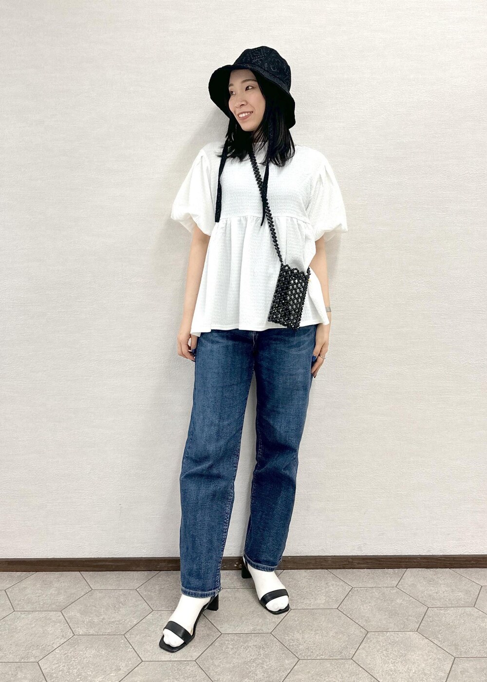 ブラック系のショルダーバッグ、ブルー系のデニムパンツ、ホワイト系のシャツ/ブラウスを着用したレディースの春コーディネートの2枚目の写真