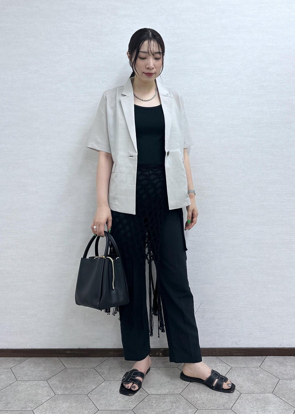 ブラック系のショルダーバッグ、ベージュ系のテーラードジャケット、グレー系のその他パンツを着用したレディースの夏コーディネートの3枚目の写真
