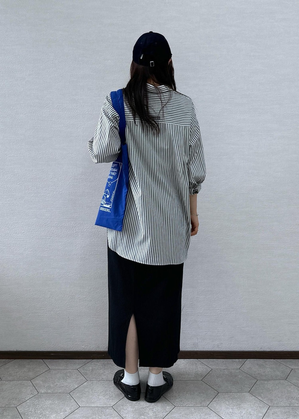 ブラック系のスカート、ホワイト系のシャツ/ブラウス、ブルー系のトートバッグを着用したレディースの秋コーディネートの4枚目の写真