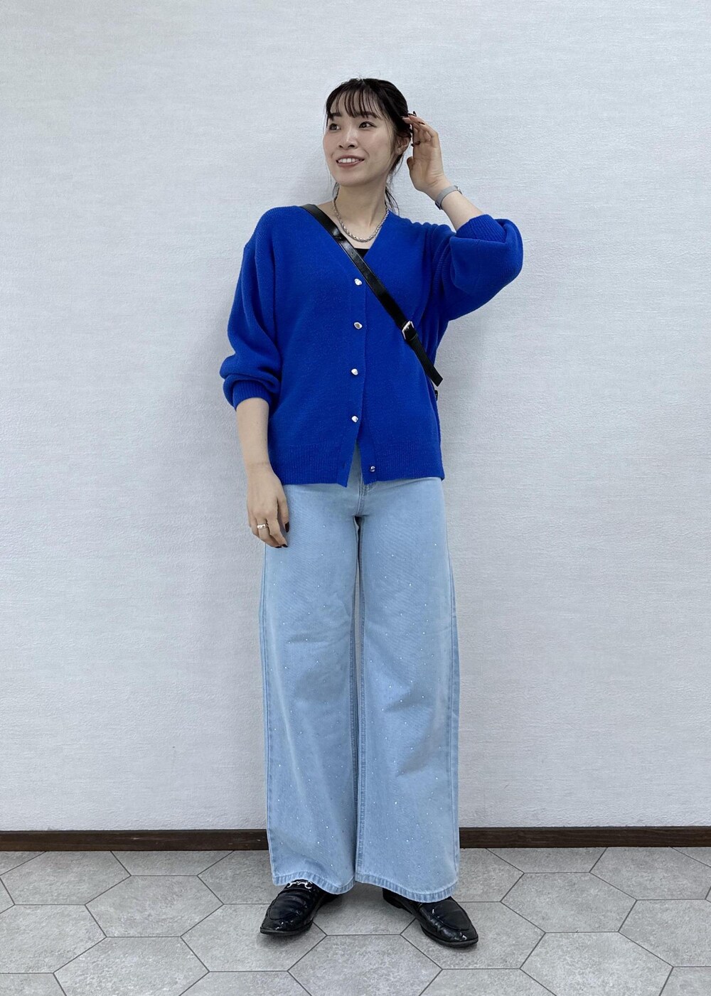 ブルー系のカーディガン/ボレロ、ブラック系のショルダーバッグ、ブルー系のデニムパンツを着用したレディースの秋コーディネートの3枚目の写真