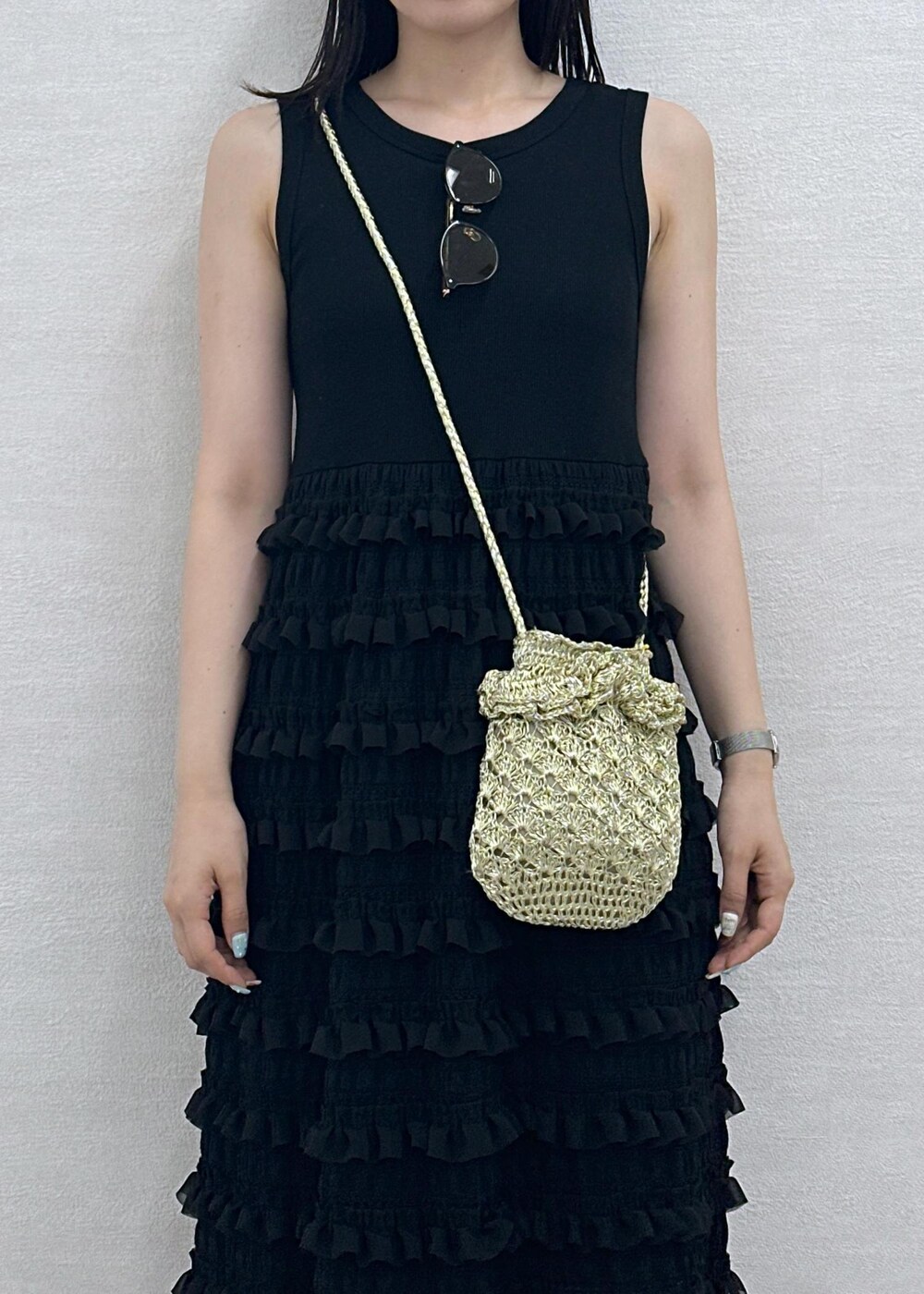 ゴールド系のショルダーバッグ、ブラック系のワンピース、ブラウン系のサングラスを着用したレディースの夏コーディネートの5枚目の写真