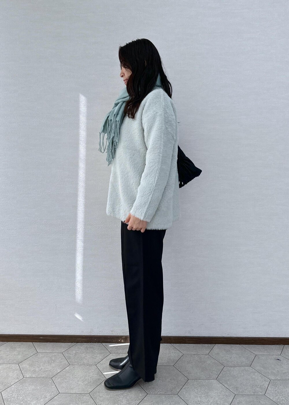 ブラック系のその他パンツ、ブラック系のブーツ、ブラック系のショルダーバッグを着用したレディースの冬コーディネートの4枚目の写真