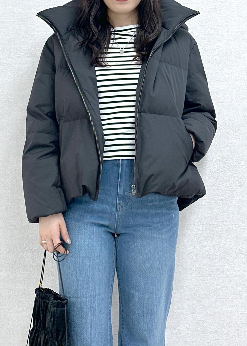 ブラック系のダウンジャケット/コート、ホワイト系のTシャツ/カットソー、ブルー系のデニムパンツを着用したレディースの冬コーディネートの6枚目の写真