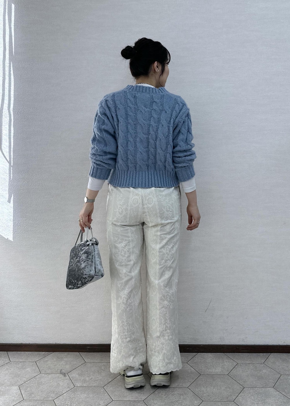 シルバー系のハンドバッグ、ホワイト系のその他パンツ、ブルー系のカーディガン/ボレロを着用したレディースの冬コーディネートの5枚目の写真