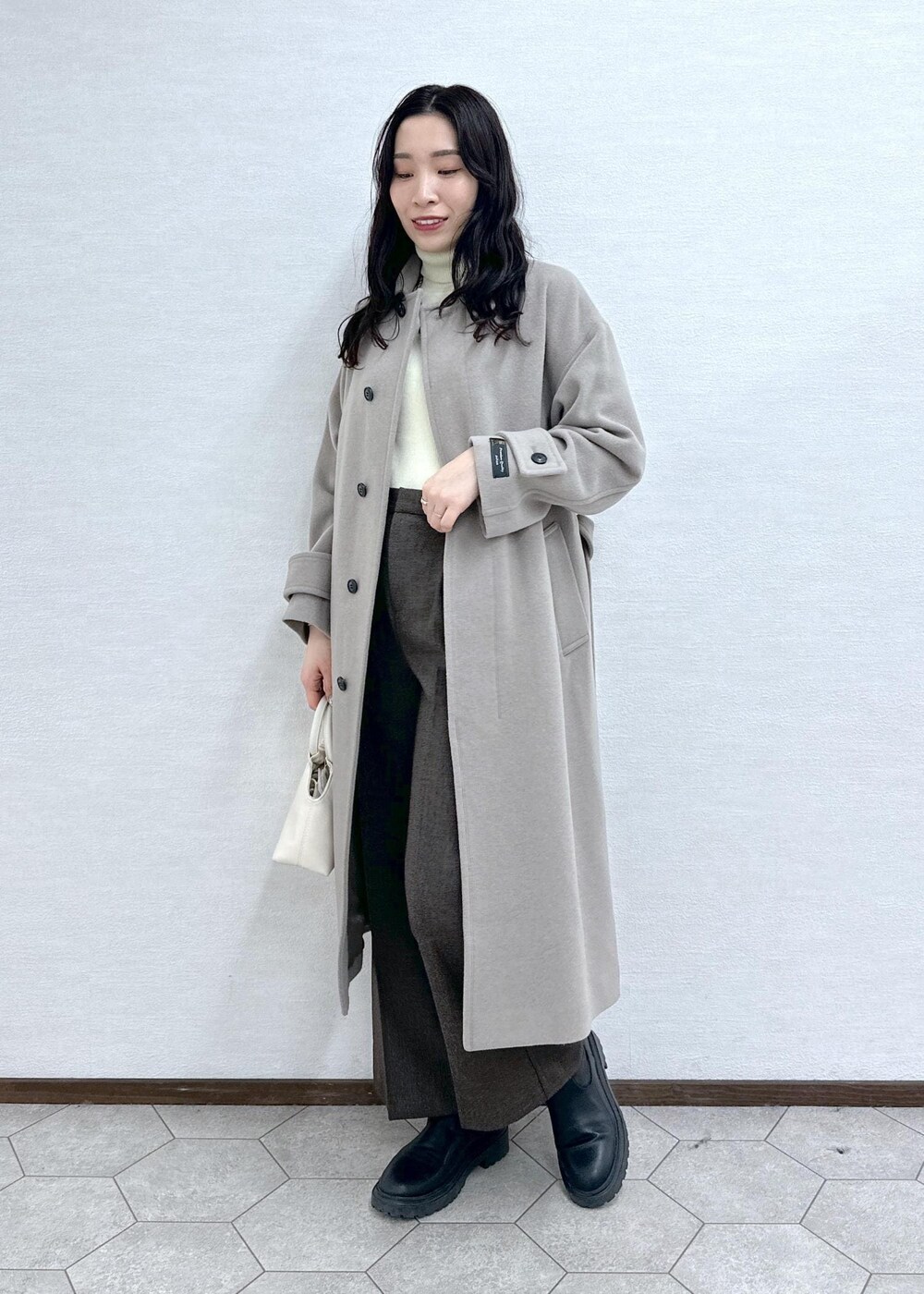 ホワイト系のニット/セーター、ブラウン系のその他アウター、ブラウン系のその他パンツを着用したレディースの冬コーディネートの2枚目の写真