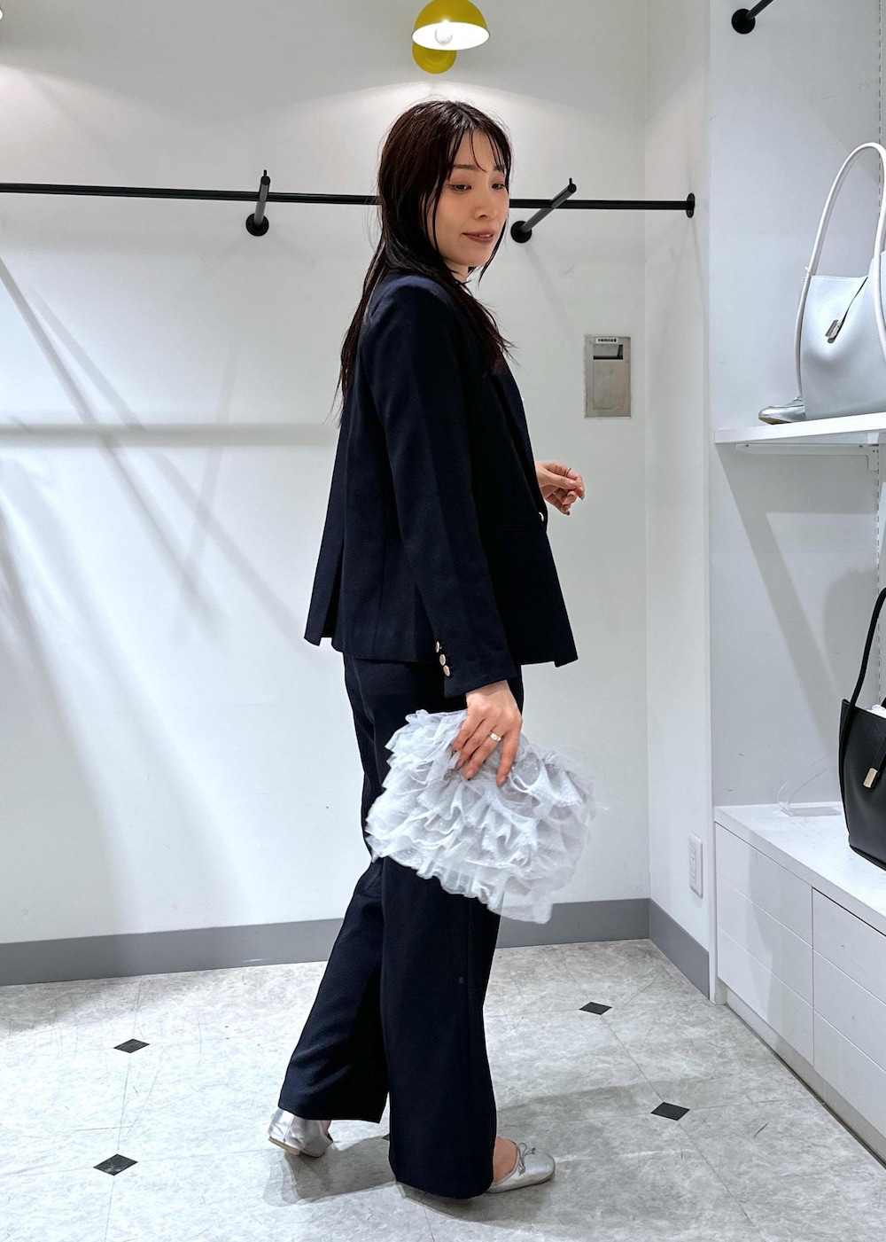 シルバー系のバレエシューズ、グレー系のショルダーバッグ、ブルー系のスラックスを着用したレディースの夏コーディネートの4枚目の写真