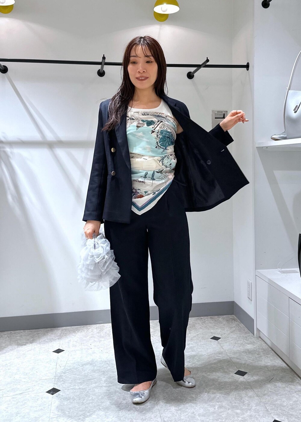 シルバー系のバレエシューズ、グレー系のショルダーバッグ、ブルー系のスラックスを着用したレディースの夏コーディネートの3枚目の写真