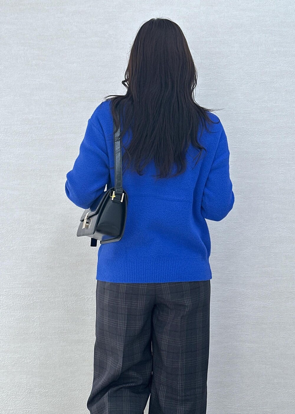 ブラック系のショルダーバッグ、ブルー系のニット/セーター、ホワイト系のTシャツ/カットソーを着用したレディースの秋コーディネートの9枚目の写真