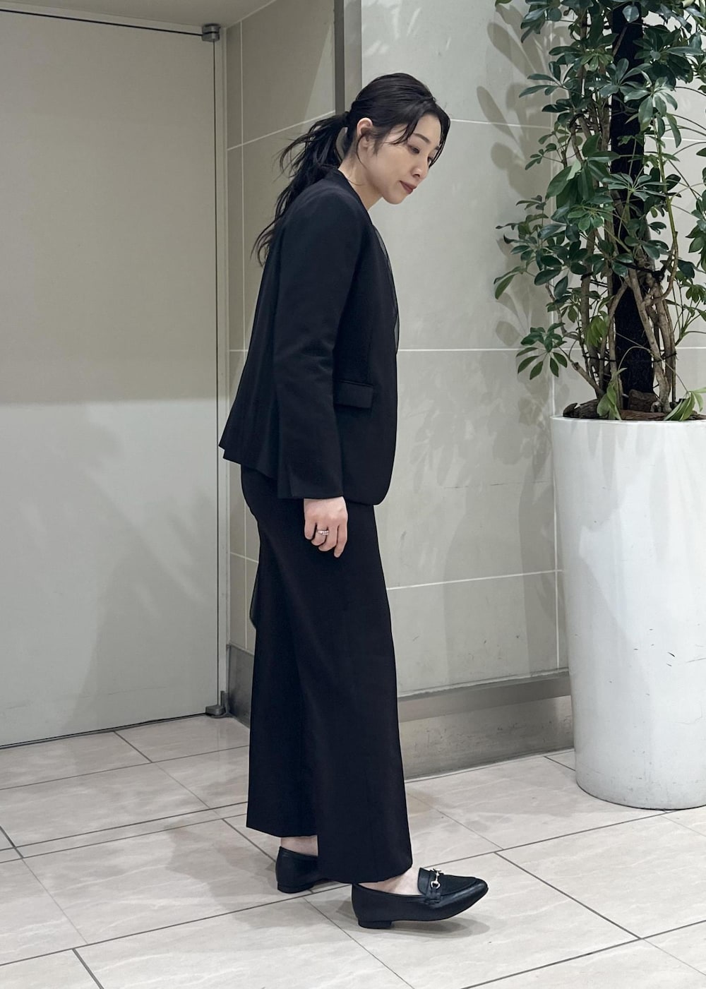 ブラック系のニット/セーター、ブラック系のローファー、ブラック系のノーカラージャケットを着用したレディースの冬コーディネートの6枚目の写真