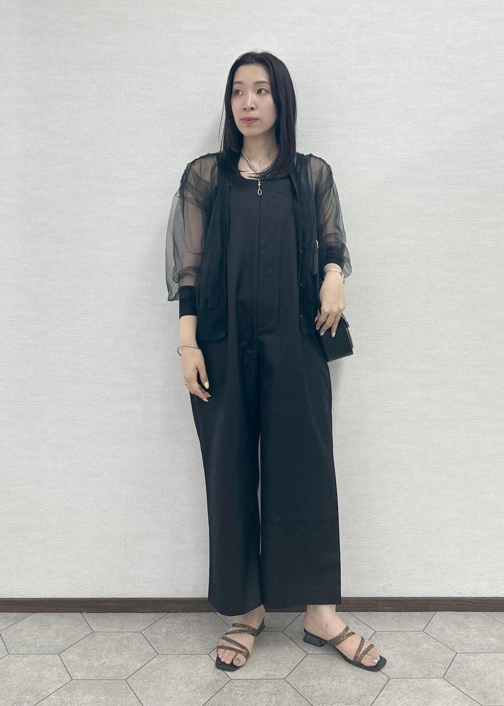 ブラック系のつなぎ/オールインワン、ブラック系のショルダーバッグ、ブラック系のカーディガン/ボレロを着用したレディースの夏コーディネートの2枚目の写真