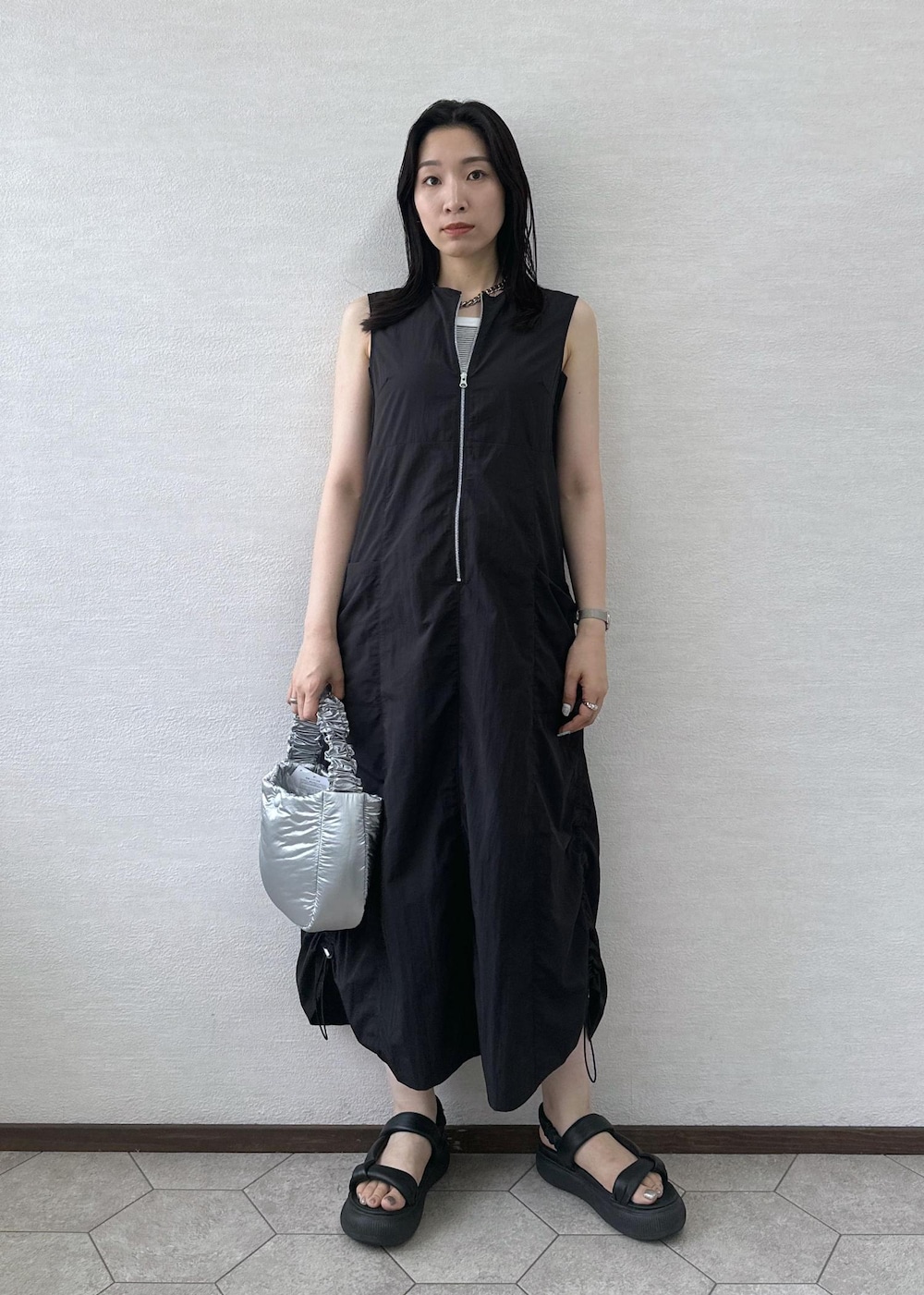 ブラック系のワンピース、シルバー系のショルダーバッグを着用したレディースの夏コーディネートの3枚目の写真