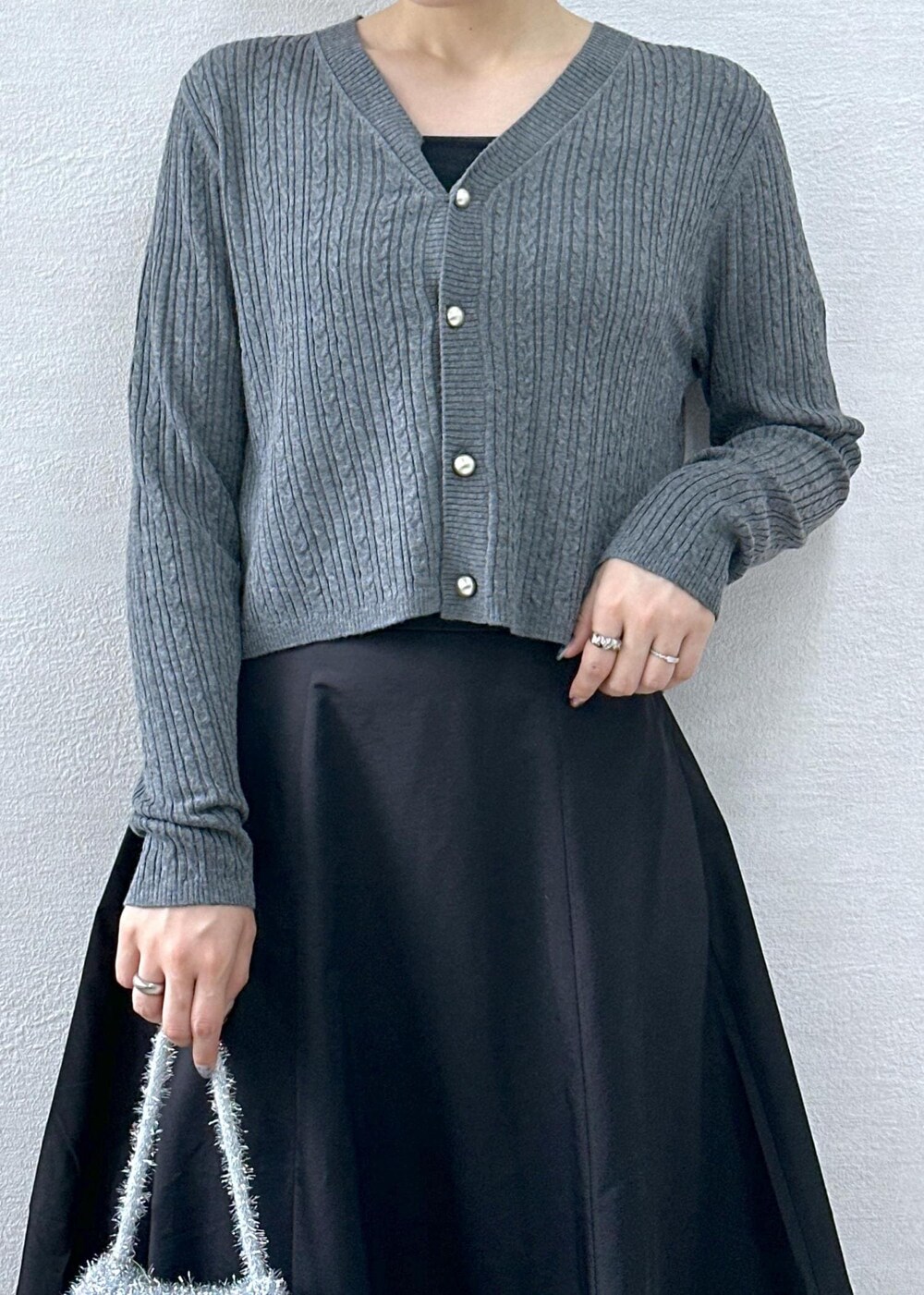 ブラック系のスカート、グレー系のカーディガン/ボレロ、シルバー系のショルダーバッグを着用したレディースの秋コーディネートの6枚目の写真