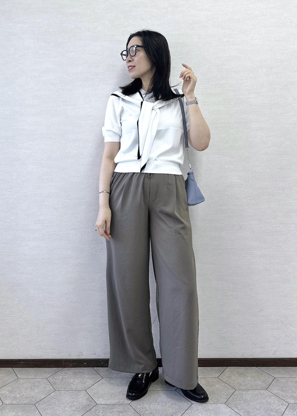グレー系のショルダーバッグ、グリーン系のその他パンツ、ホワイト系のニット/セーターを着用したレディースの夏コーディネートの2枚目の写真