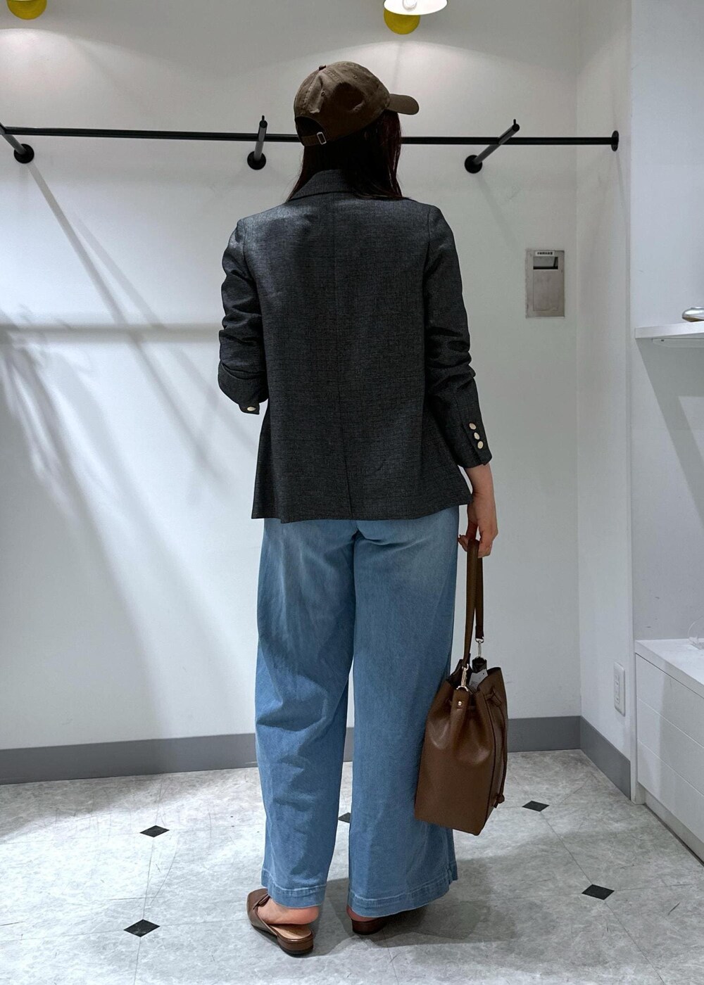 ブルー系のデニムパンツ、イエロー系のローファー、ブラウン系のショルダーバッグを着用したレディースの夏コーディネートの6枚目の写真