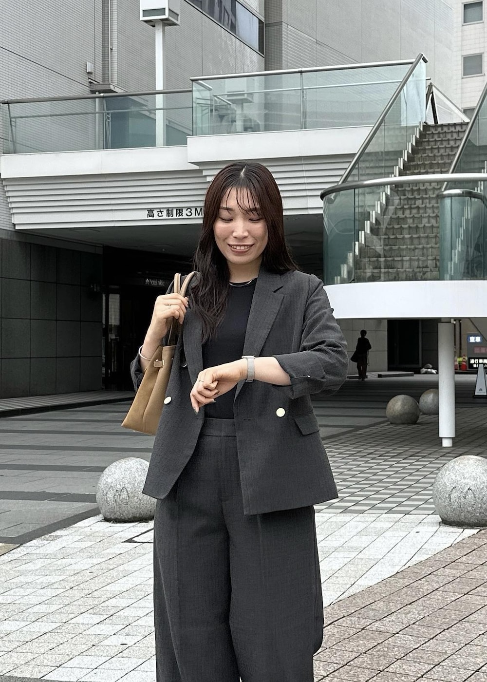 ブラック系のタンクトップ、イエロー系のトートバッグ、ブラック系のテーラードジャケットを着用したレディースの秋コーディネートの6枚目の写真