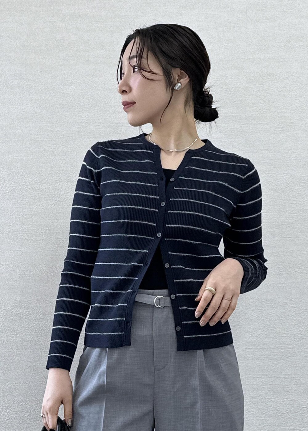 ブラック系のトートバッグ、ブラック系のタンクトップ、ブルー系のカーディガン/ボレロを着用したレディースの春コーディネートの9枚目の写真