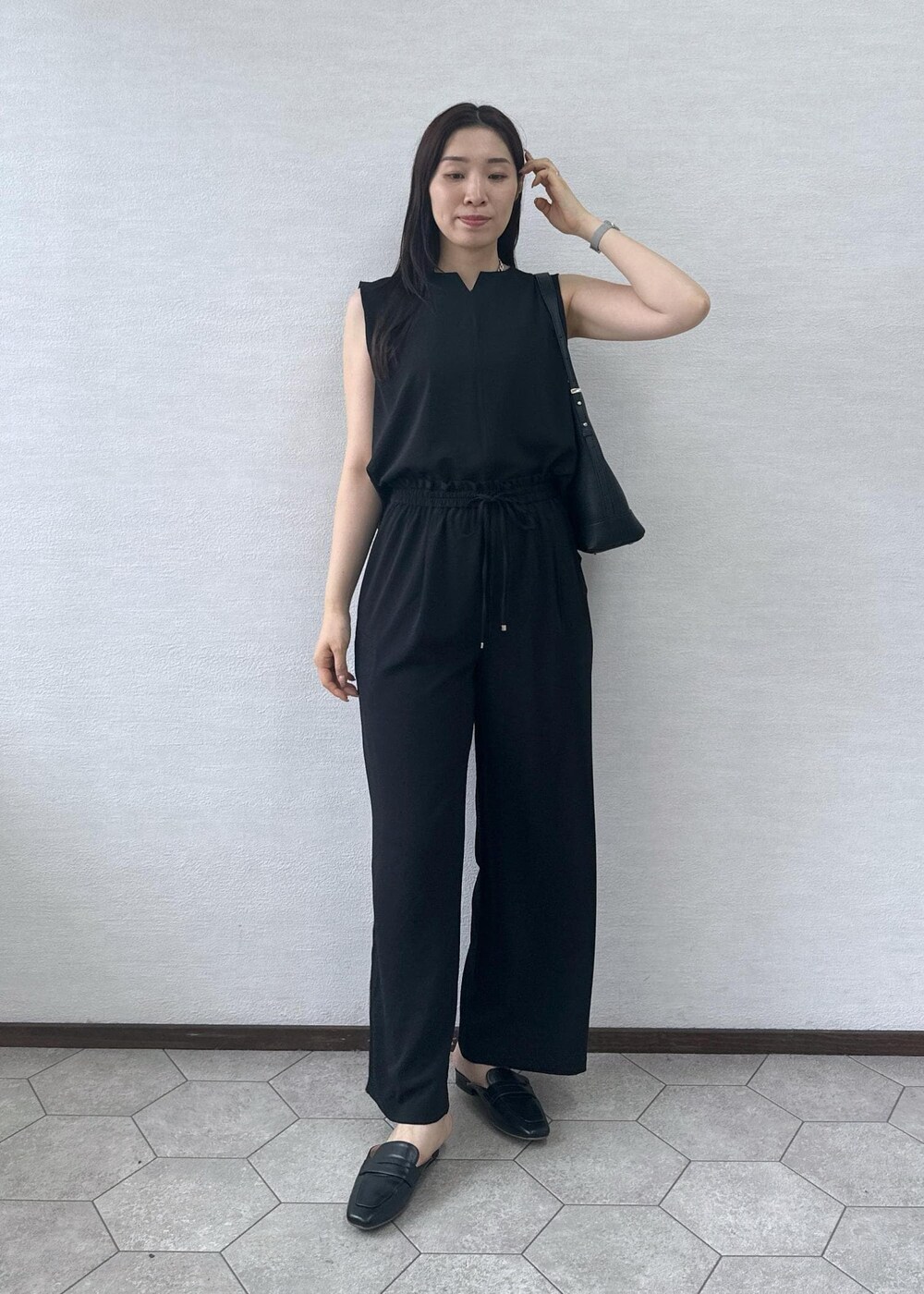 ブラック系のローファー、ブラック系のショルダーバッグ、ブラック系のその他パンツを着用したレディースの夏コーディネートの3枚目の写真