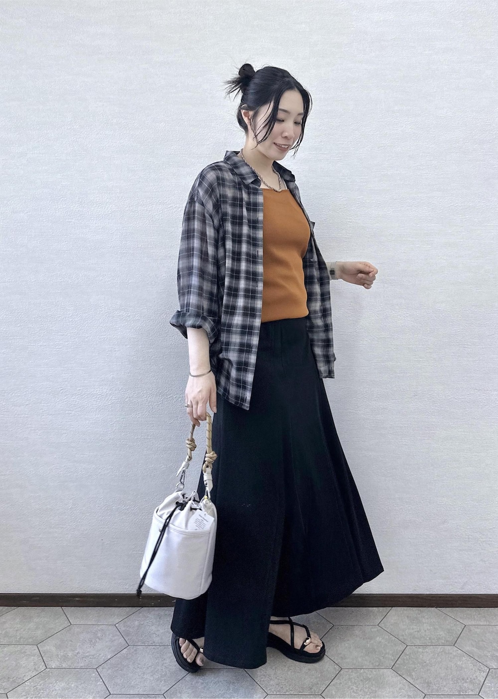 グレー系のショルダーバッグ、ブラック系のサンダル、イエロー系のタンクトップを着用したレディースの夏コーディネートの3枚目の写真