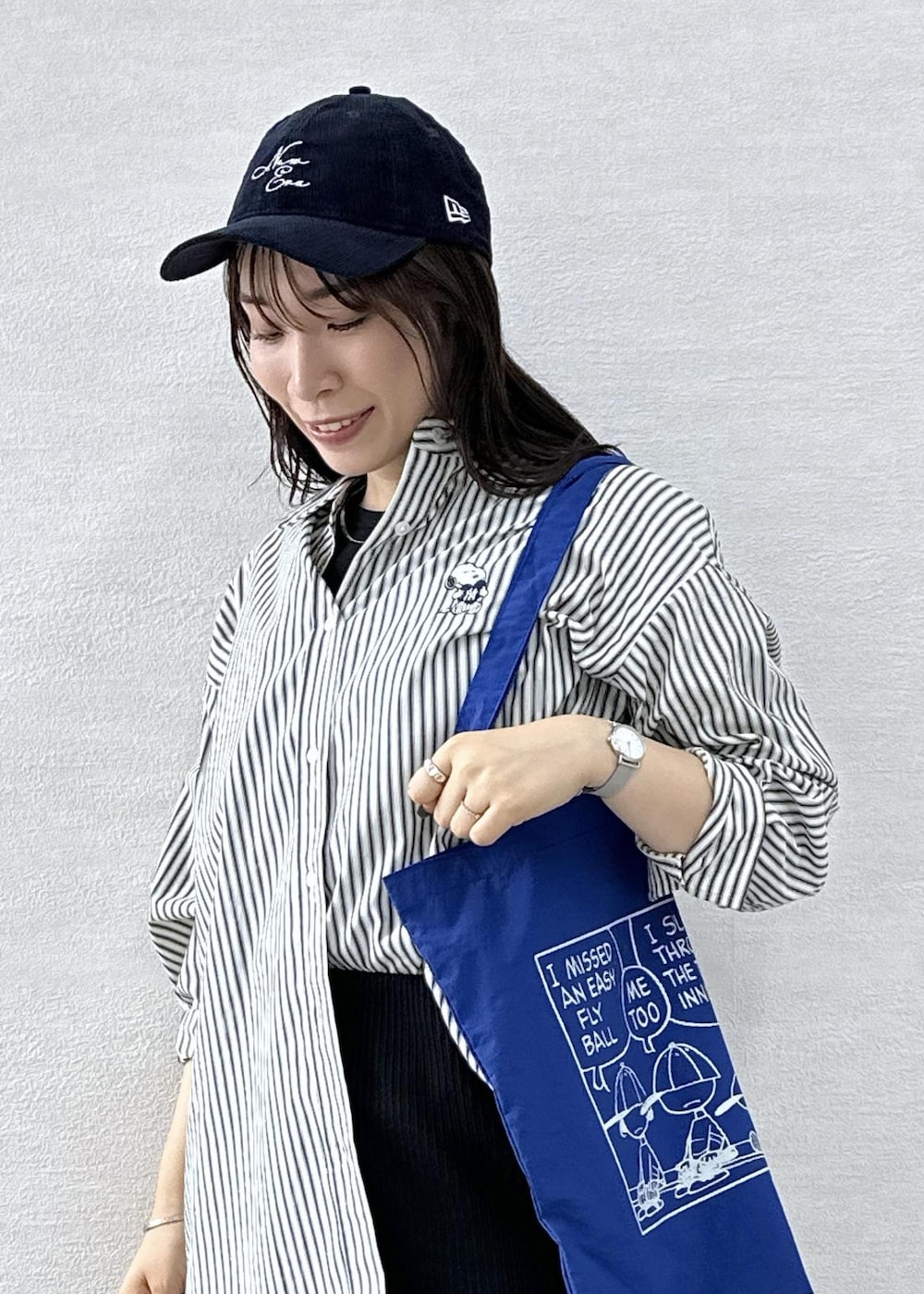 ブラック系のスカート、ホワイト系のシャツ/ブラウス、ブルー系のトートバッグを着用したレディースの秋コーディネートの7枚目の写真