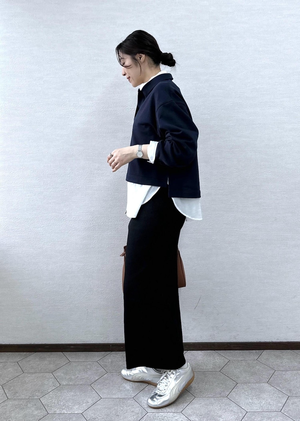 ブラック系のスカート、イエロー系のトートバッグ、ブルー系のスウェットを着用したレディースの春コーディネートの3枚目の写真