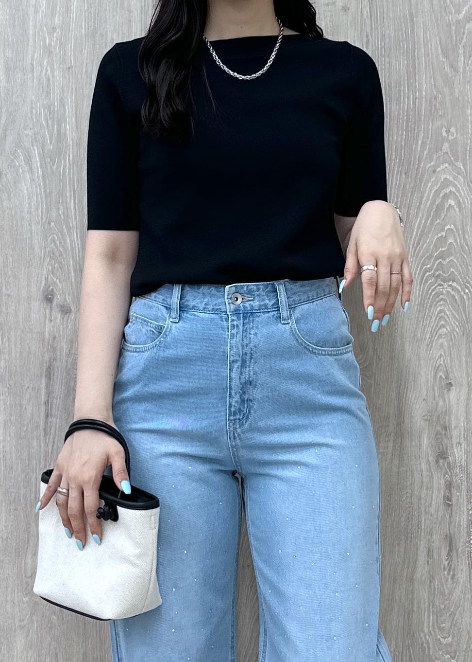 ブルー系のデニムパンツ、ブラック系のニット/セーター、ブラック系のトートバッグを着用したレディースの夏コーディネートの7枚目の写真