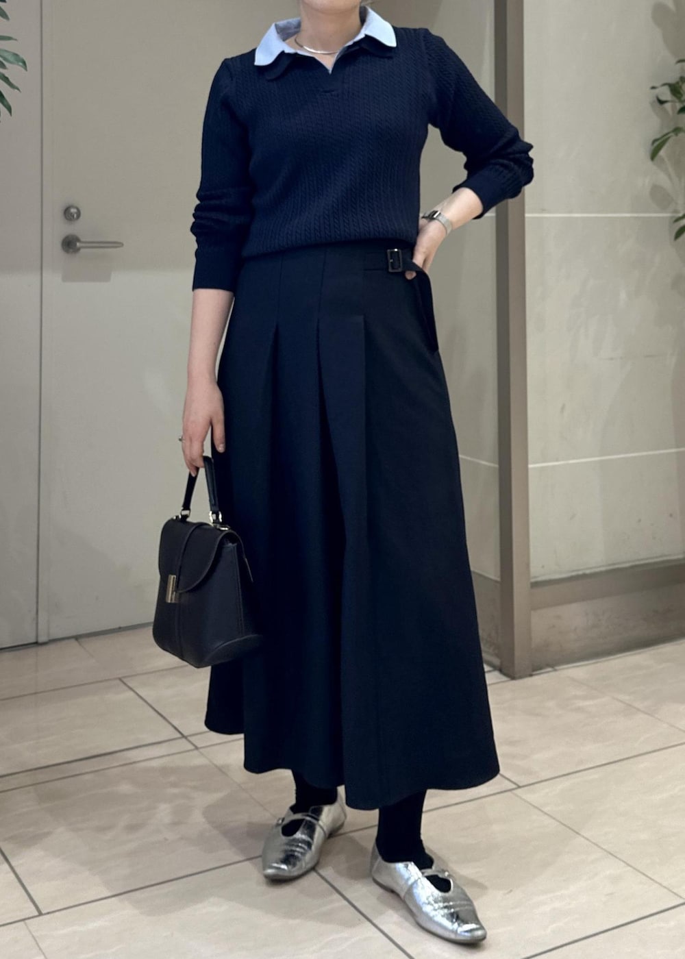 ブルー系のスカート、ブルー系のニット/セーター、ブラック系のショルダーバッグを着用したレディースの冬コーディネートの5枚目の写真