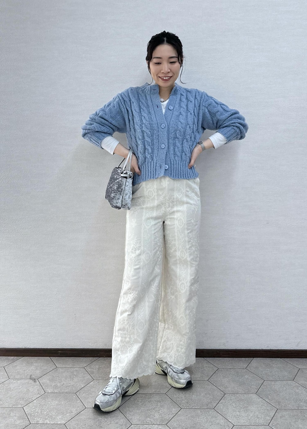 シルバー系のハンドバッグ、ホワイト系のその他パンツ、ブルー系のカーディガン/ボレロを着用したレディースの冬コーディネートの3枚目の写真