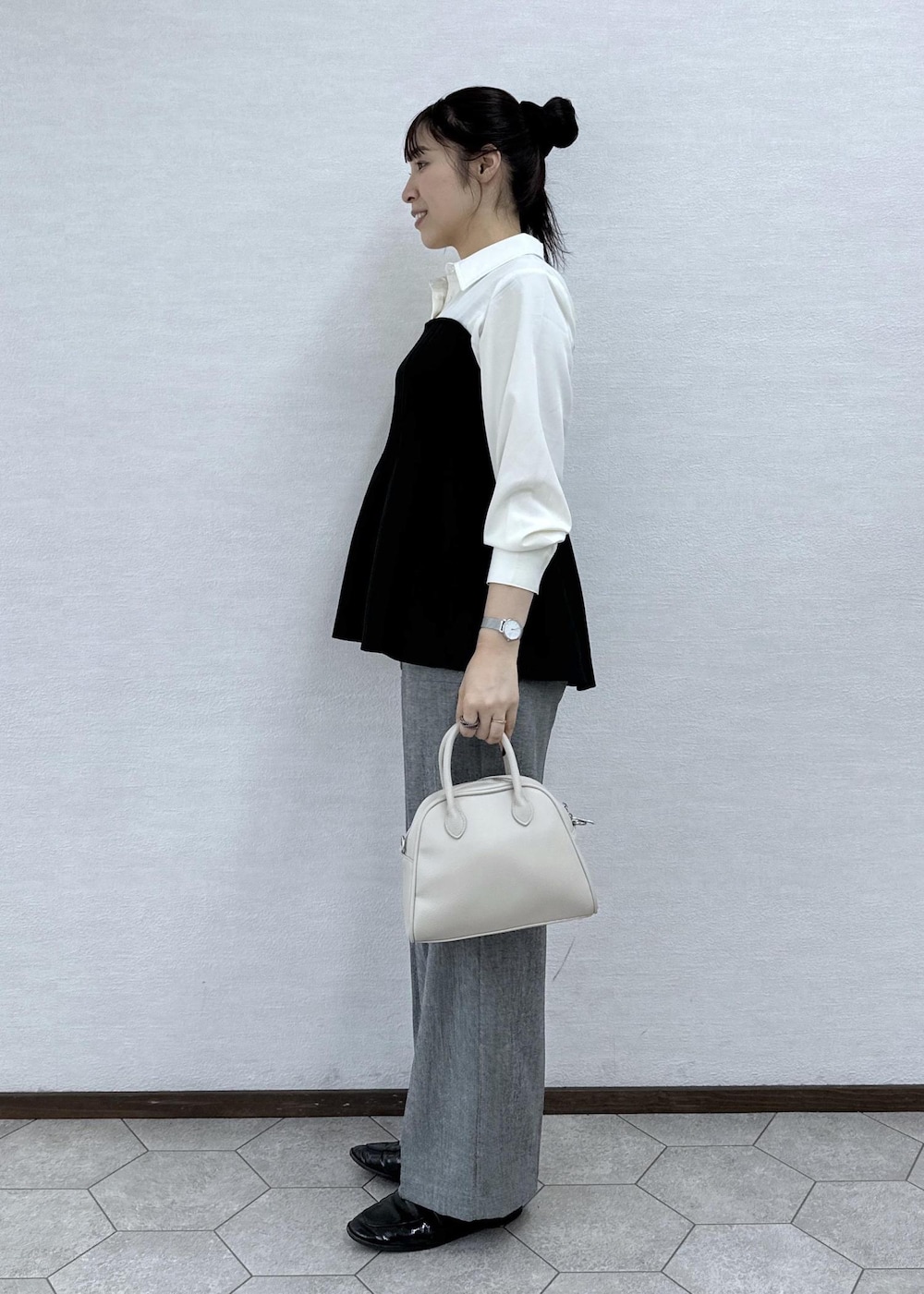 ブラック系のシャツ/ブラウス、グレー系のその他パンツ、ベージュ系のボストンバッグを着用したレディースの秋コーディネートの5枚目の写真