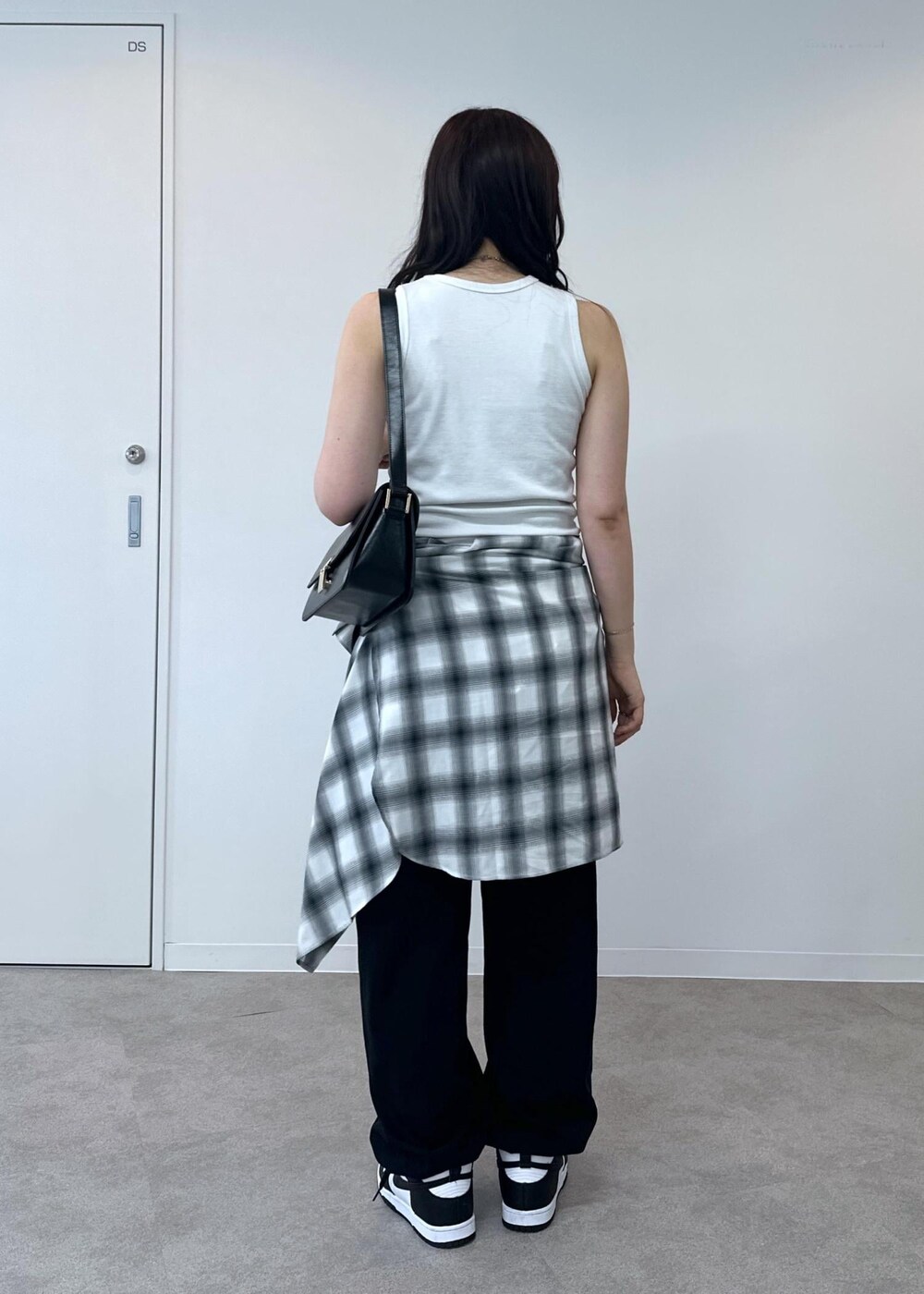 ブラック系のカーゴパンツ、ホワイト系のタンクトップ、ブラック系のショルダーバッグを着用したレディースの夏コーディネートの4枚目の写真