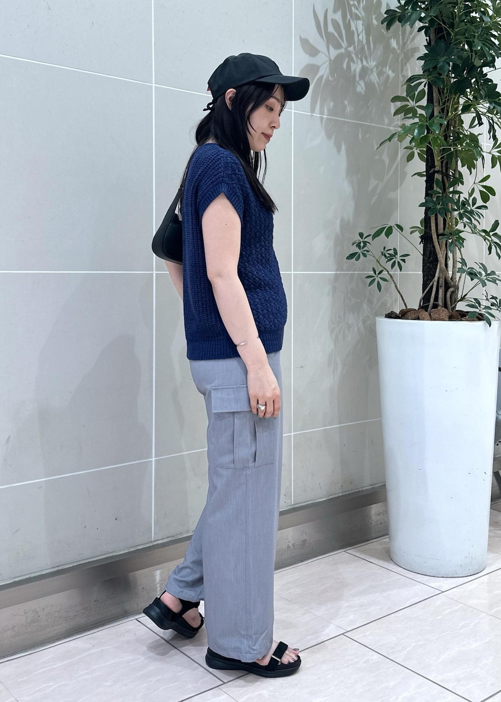 ブルー系のベスト、グレー系のカーゴパンツ、ブラック系のサンダルを着用したレディースの夏コーディネートの4枚目の写真
