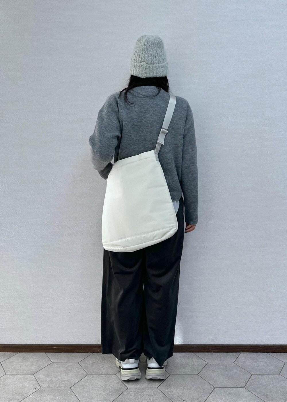 グレー系のニット/セーター、グレー系のその他パンツ、ホワイト系のトートバッグを着用したレディースの冬コーディネートの8枚目の写真