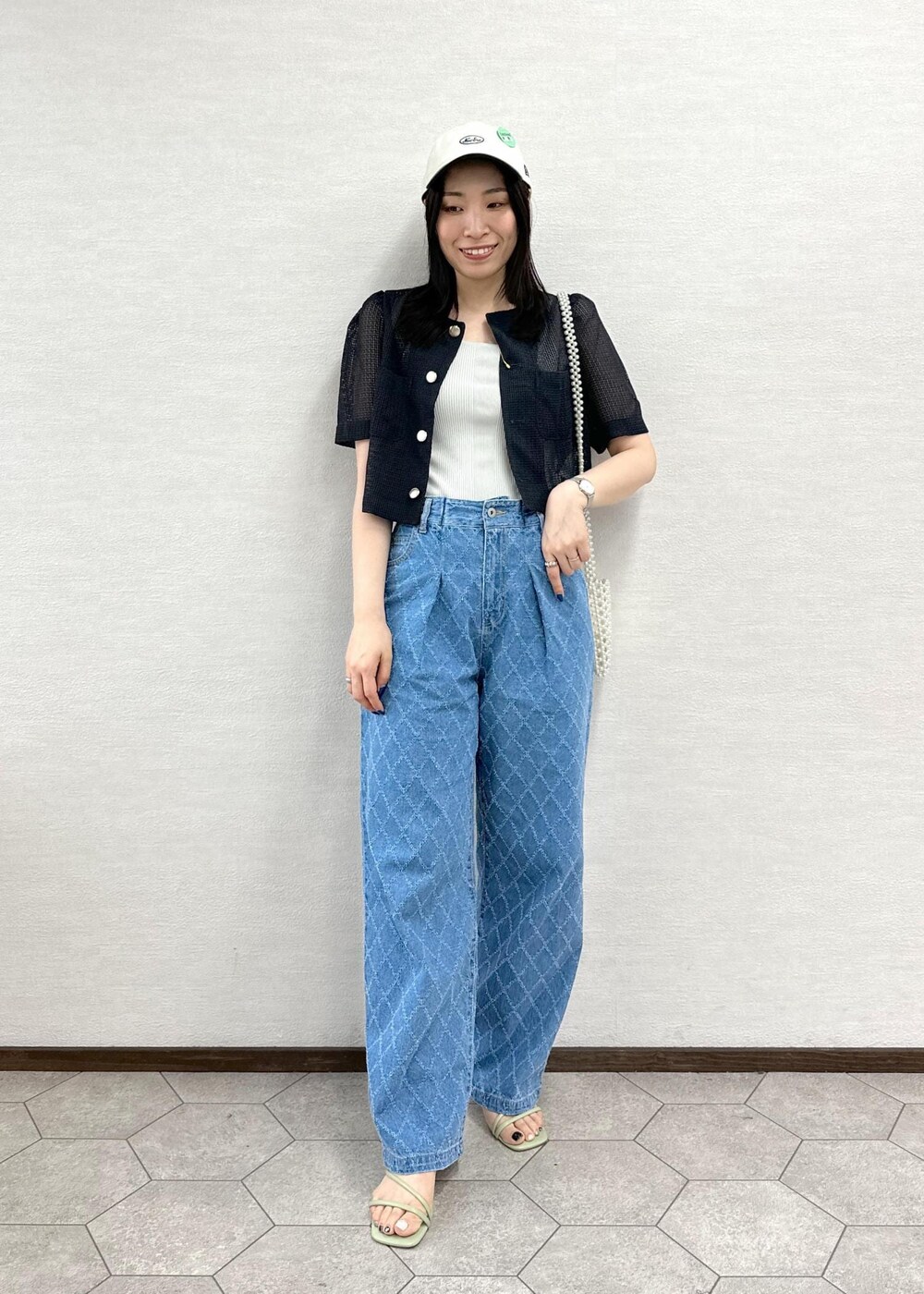 ホワイト系のショルダーバッグ、グレー系のノーカラージャケット、ブルー系のデニムパンツを着用したレディースの夏コーディネートの2枚目の写真