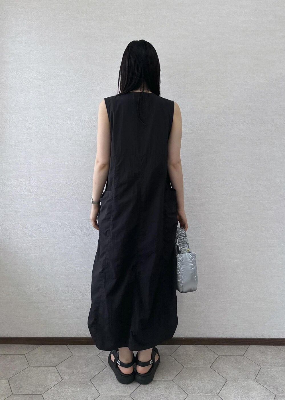 ブラック系のワンピース、シルバー系のショルダーバッグを着用したレディースの夏コーディネートの5枚目の写真