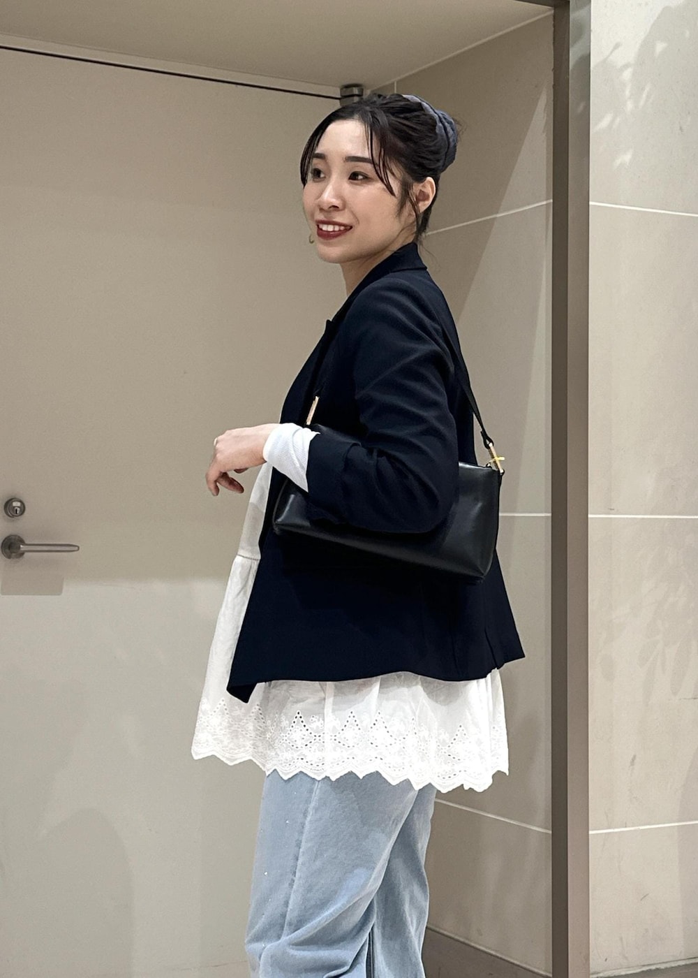 ブルー系のデニムパンツ、ブラック系のショルダーバッグ、ブルー系のテーラードジャケットを着用したレディースの冬コーディネートの7枚目の写真