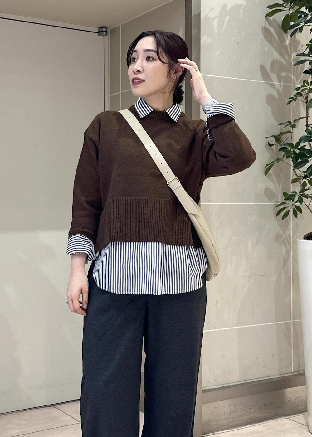 グレー系のその他パンツ、ブルー系のシャツ/ブラウス、ホワイト系のスニーカーを着用したレディースの冬コーディネートの6枚目の写真