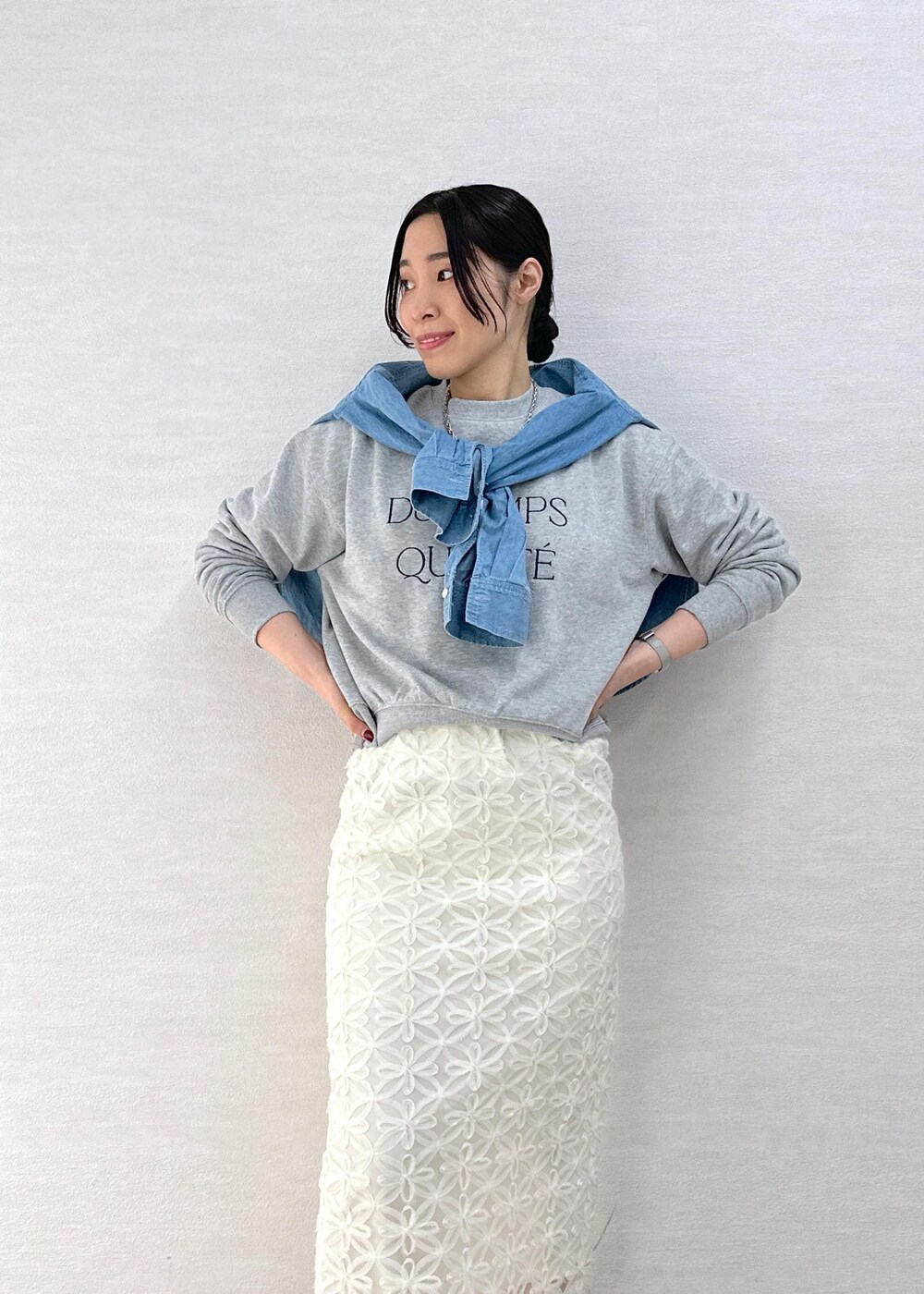 ブラック系のスカート、ブルー系のシャツ/ブラウス、グレー系のスウェットを着用したレディースの春コーディネートの6枚目の写真